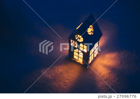 Lantern house with burning candle on snow in the Lantern house with burning candle on snow in the 27096776