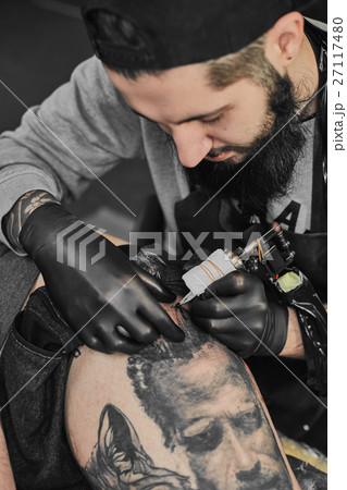 Tattoo master is tattooing in the tattoosalon Tattoo master is tattooing in the tattoosalon 27117480