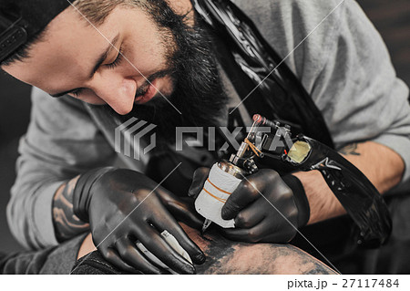 Tattoo master is tattooing in the tattoosalon 27117484