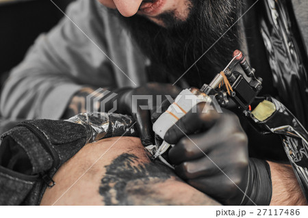 Tattoo master is tattooing in the tattoosalon Tattoo master is tattooing in the tattoosalon 27117486