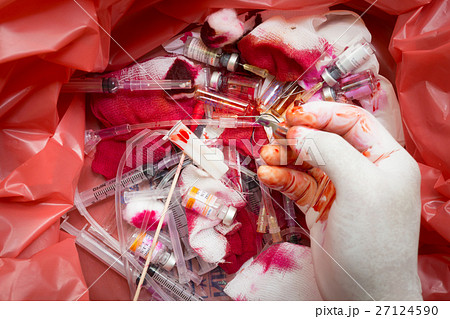 Hand with glove over on infectious wastes in bag Hand with glove over on infectious wastes in bag 27124590