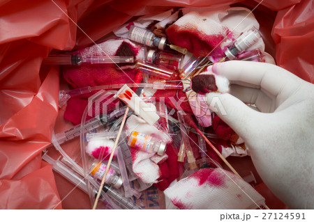 Hand with glove over on infectious wastes in bag Hand with glove over on infectious wastes in bag 27124591