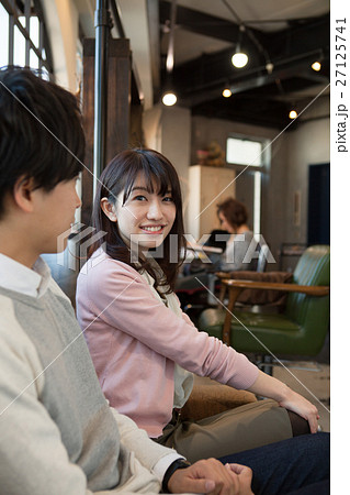 美容室でくつろぐ代カップルの写真素材