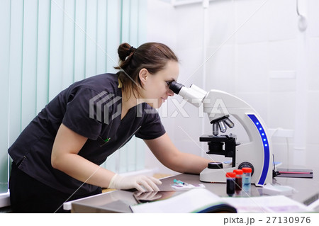 Female scientist studying new substance or virus in microscope Female scientist studying new substance or virus in microscope 27130976