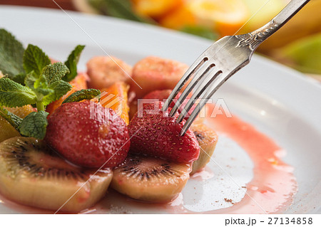 Fruit flambe on white plate. Fruit flambe on white plate. 27134858