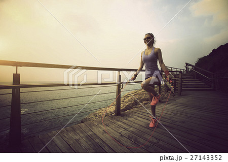 young fitness woman skipping rope at seaside 27143352