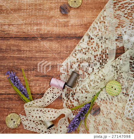Lace and thread on wooden background 27147098
