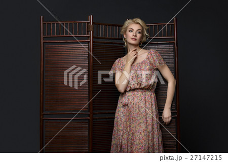 Beautiful girl standing near folding screen Beautiful girl standing near folding screen 27147215