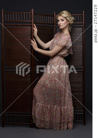 Beautiful girl standing near folding screen  27147229