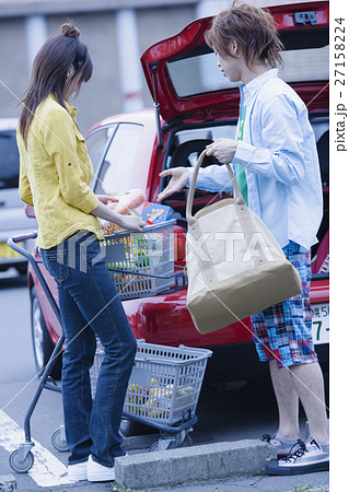 車に荷物を積むカップル 27158224