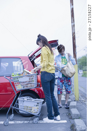 車に荷物を積むカップル 27158227