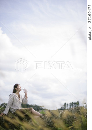 草むらで水を飲む女性 草むらで水を飲む女性 27160472
