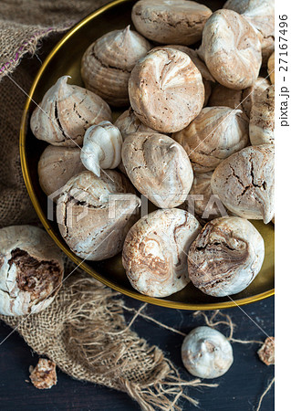 Meringue with chocolate on bronze tray close up. Meringue with chocolate on bronze tray close up. 27167496