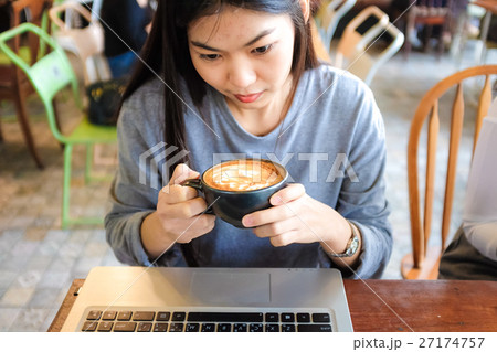Beautiful young asian woman with coffee use laptop Beautiful young asian woman with coffee use laptop 27174757