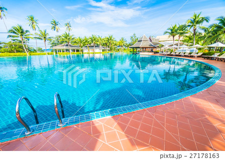 Umbrella and chair around swimming pool 27178163