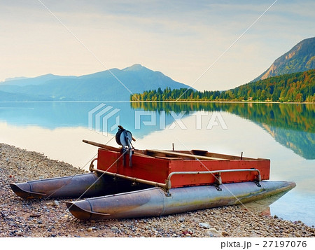 Abandoned fishing boat on bank of Alps lake. Abandoned fishing boat on bank of Alps lake. 27197076