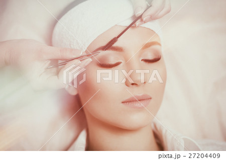 Beautiful young woman gets eyebrow correction Beautiful young woman gets eyebrow correction 27204409