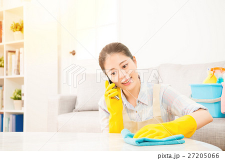 girl cleaning and speaking on phone 27205066