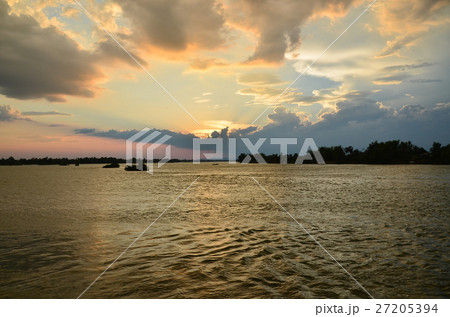 ラオスのシーパンドン　デット島から眺めるメコン川と夕日と川を行き交うボート 27205394