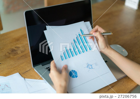 Business woman hand with Financial charts and laptop on the table . 27206756