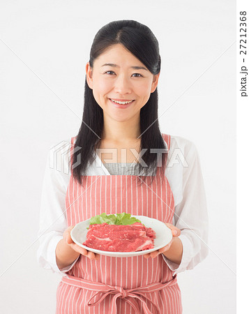 牛肉をのせた皿を持つ女性の写真素材