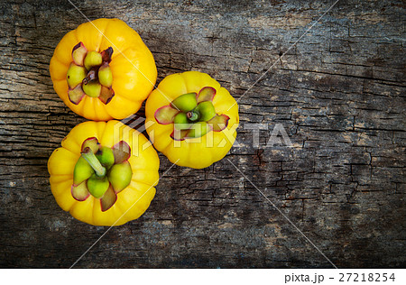Garcinia cambogia fresh fruit on wood background. 27218254
