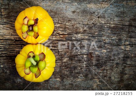Garcinia cambogia fresh fruit on wood background. 27218255