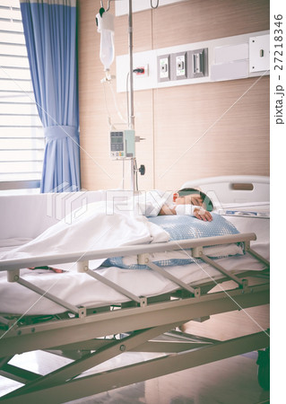 Asian boy lying on sickbed with saline intravenous (IV).  27218346