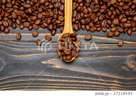 wooden spoon of roasted coffee beans on table 27219595
