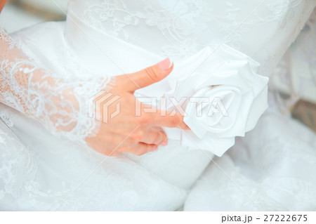 bridesmaid makes bow-knot on the back of brides bridesmaid makes bow-knot on the back of brides 27222675