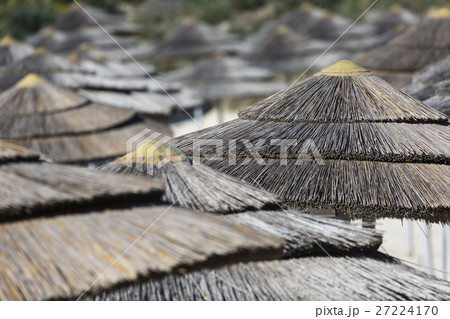woven umbrellas above rows on beach in Cyprus. woven umbrellas above rows on beach in Cyprus. 27224170