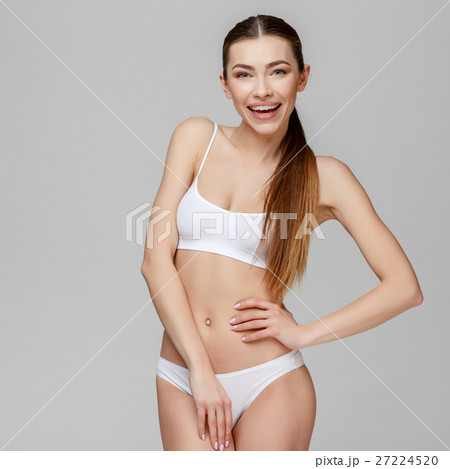 Slim tanned woman's body over gray background 27224520