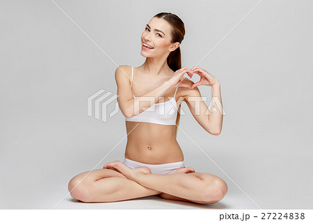 Slim tanned woman's body over gray background 27224838