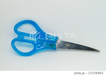 Blue scissors laying on the white paper Blue scissors laying on the white paper 27236902