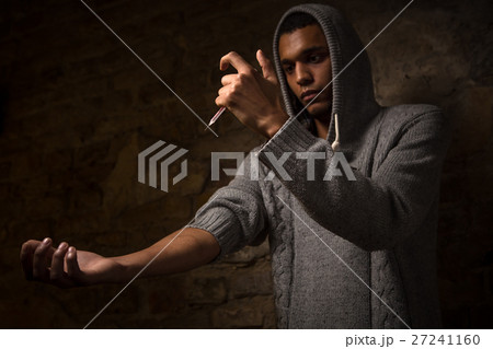 Drug addict posing near brick wall 27241160
