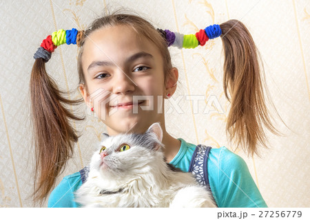 girl with two funny ponytails holding the cat 27256779