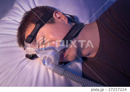 Middle age asian man with sleep apnea using CPAP 27257224