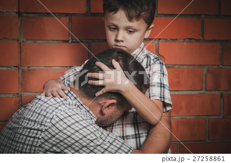 Portrait of sad son hugging his dad 27258861
