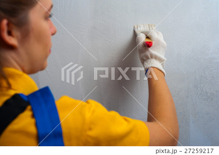 Female painter decorating the wall with brush Female painter decorating the wall with brush 27259217