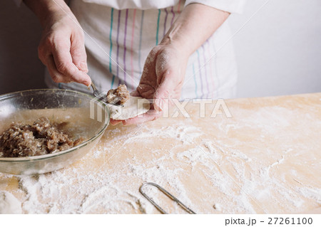 Two hands making meat dumplings. 27261100