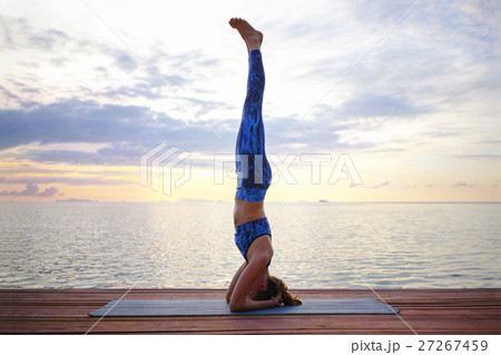 Young woman practicing yoga on the sunset beach 27267459