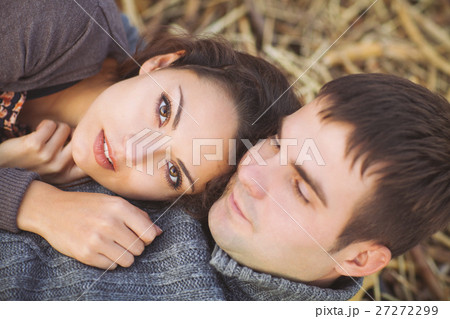 Happy young couple lying down at autumn background Happy young couple lying down at autumn background 27272299