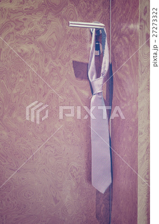 Vintage toned tie hanging on a hotel door handle. 27273322