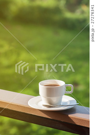 White cup of hot coffee on balcony with natural background. White cup of hot coffee on balcony with natural background. 27276341