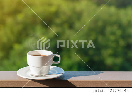 White cup of hot coffee on balcony with natural background. 27276343