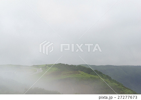 阿蘇ミルクロードの濃霧新緑の峠道早朝に霧がかかりトラックが霧に覆われ視界不良 阿蘇ミルクロードの濃霧新緑の峠道早朝に霧がかかりトラックが霧に覆われ視界不良 27277673