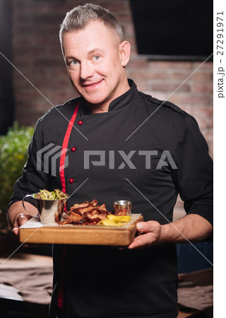Smiling man holding a tray with bacon Smiling man holding a tray with bacon 27291971