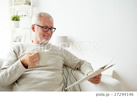 senior man in glasses reading newspaper at home senior man in glasses reading newspaper at home 27294146