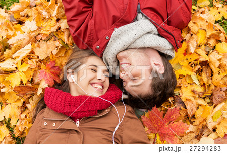 close up of smiling couple lying in autumn park 27294283