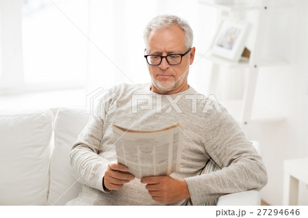 senior man in glasses reading newspaper at home senior man in glasses reading newspaper at home 27294646